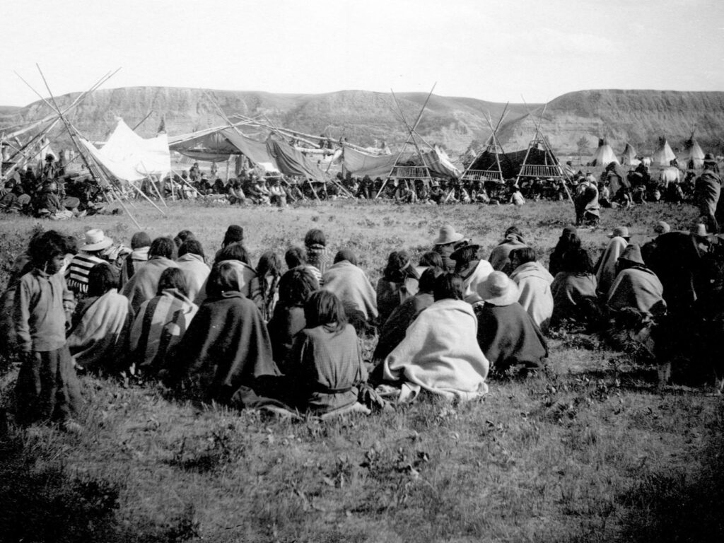 Policies in Canada made it illegal to engage in First Nations cultural and ceremonies during the early part of the 20th century. Today individuals and communities are actively engaged in reclaiming their traditional practices. This picture was taken at a Sun Dance Ceremony of the Blackfeet Nation, Gleichen, NWT, just prior to the ceremony being outlawed.